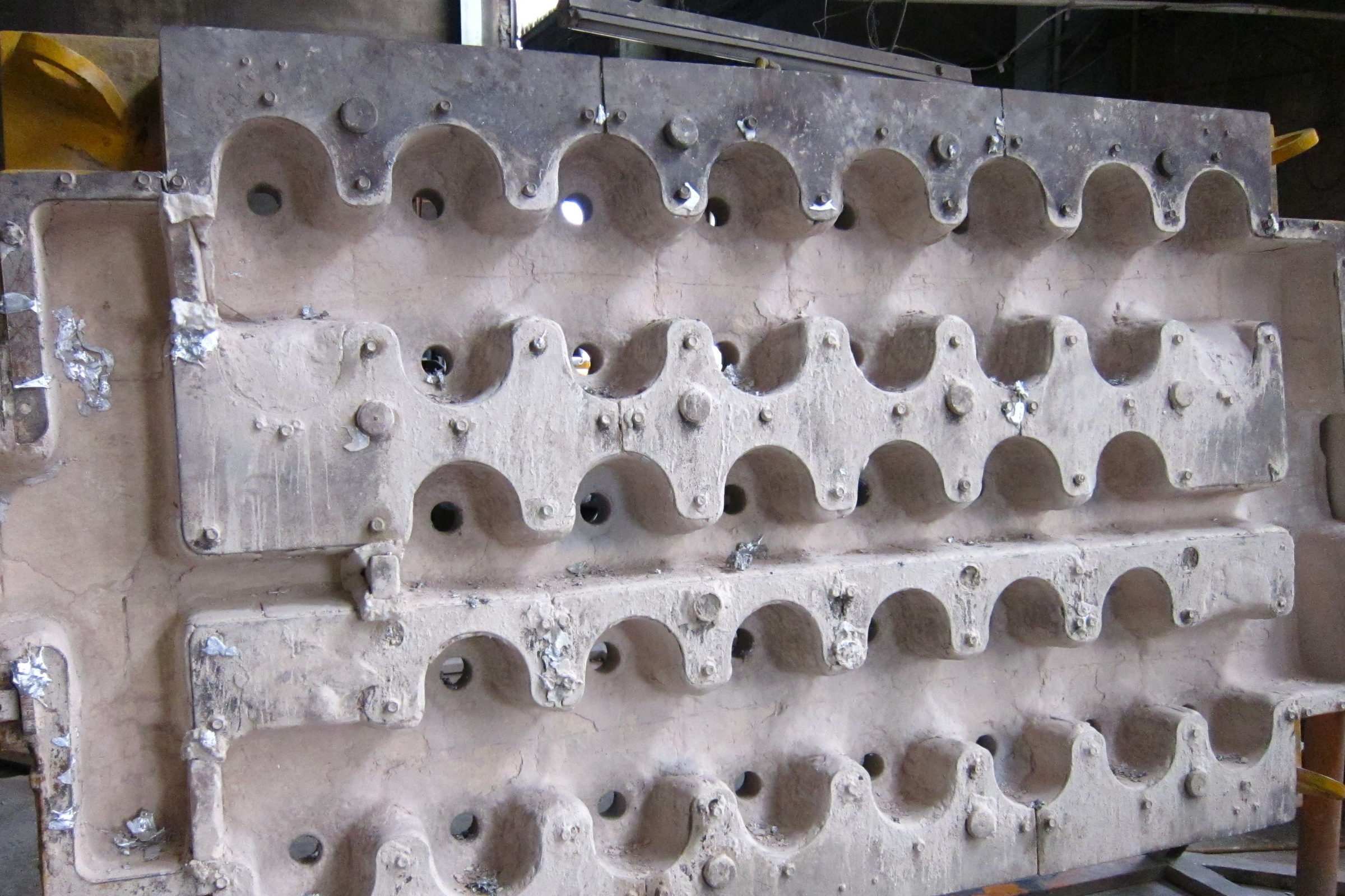Gießform für Strangguss mit hellen Metallresten, die an Rändern und Öffnungen anhaften