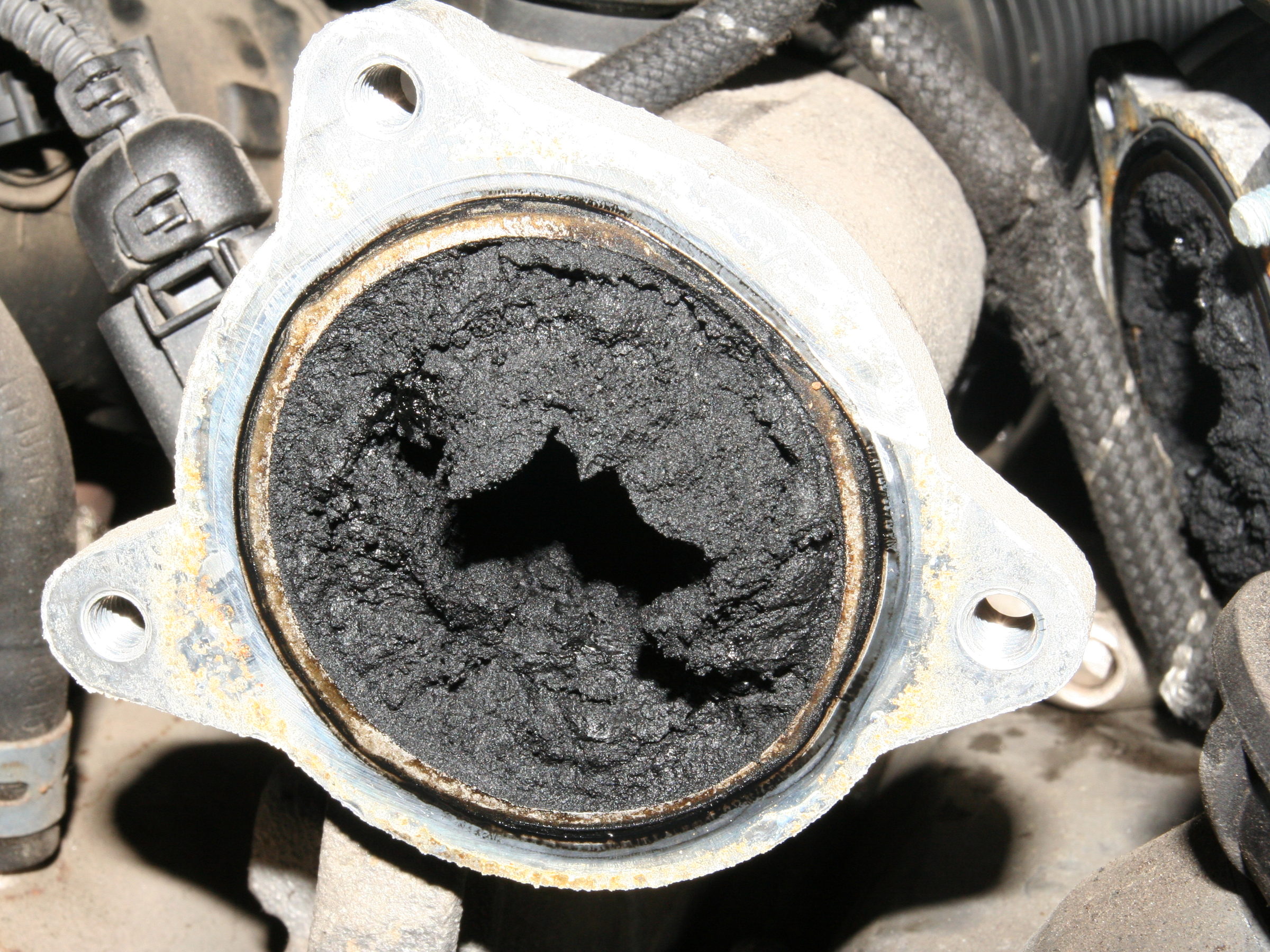 Abgasrückführung eines Dieselmotors, deren Öffnung fast vollständig mit Ruß zugesetzt ist